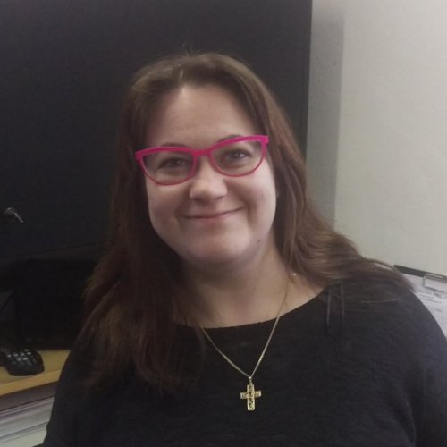 Anja Kislinger-Lehmann Eine Frau mit rosa Brille, langen braunen Haaren und schwarzem Pullover.